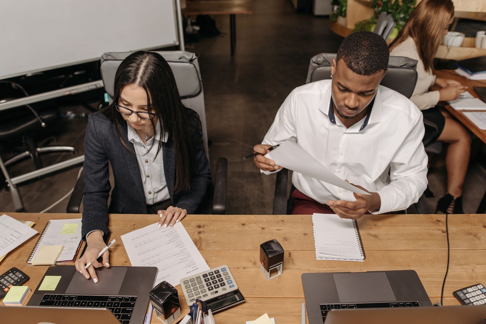 Multiracial office team working on financial documents, highlighting teamwork and productivity