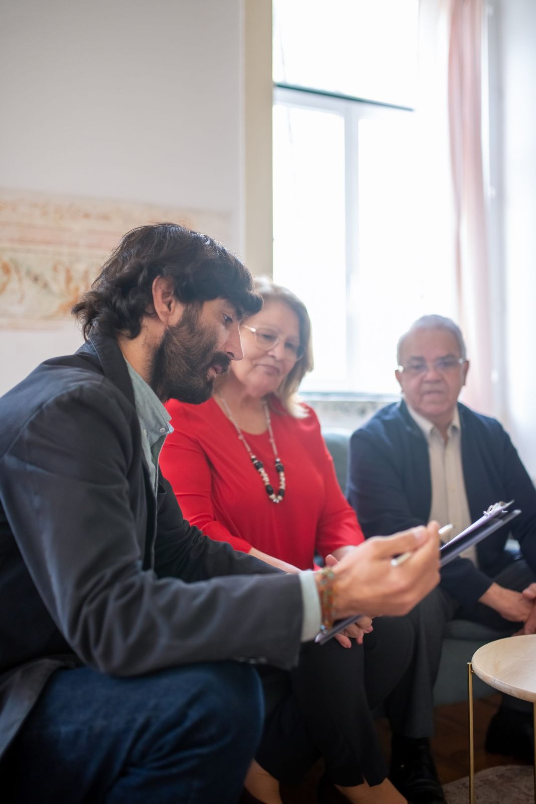 Consulting agent discussing documents with senior couple indoors during a business meeting